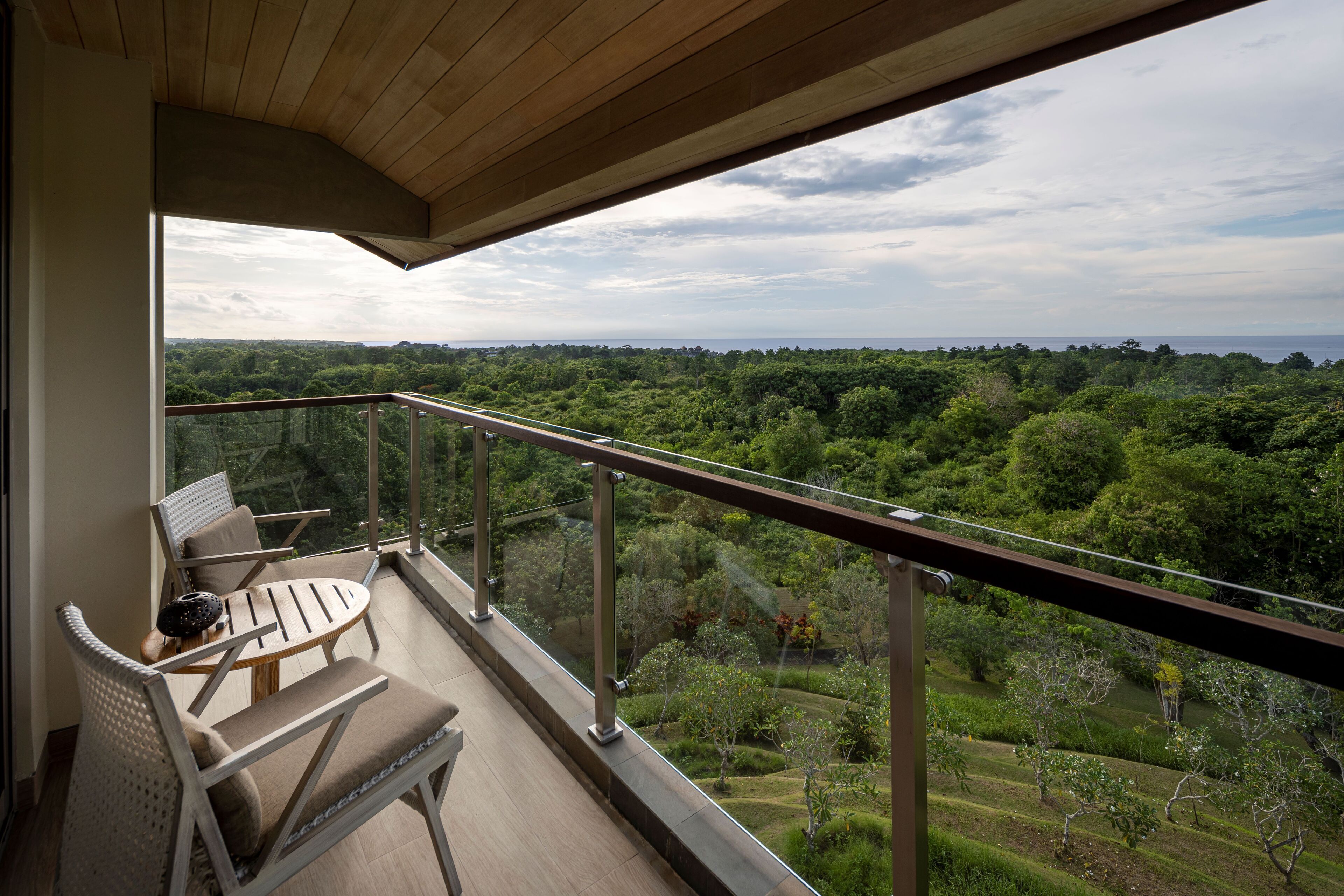 Un balcon donnant sur un paysage verdoyant et luxuriant.