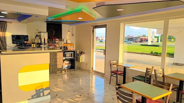 A restaurant with a bar area, seating, and a view of the outside. - Americas Best Value Inn Vandalia (Vandalia)