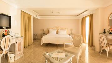 Una habitación de hotel con cama, escritorio, silla, televisor y espejo.