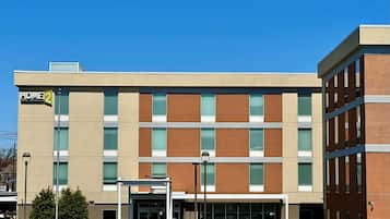 Hotel entrance with a covered outdoor area and seating.