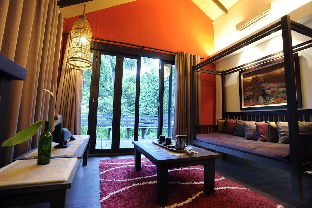 A cozy room with a sofa, a table with a tray, and a hanging light fixture.