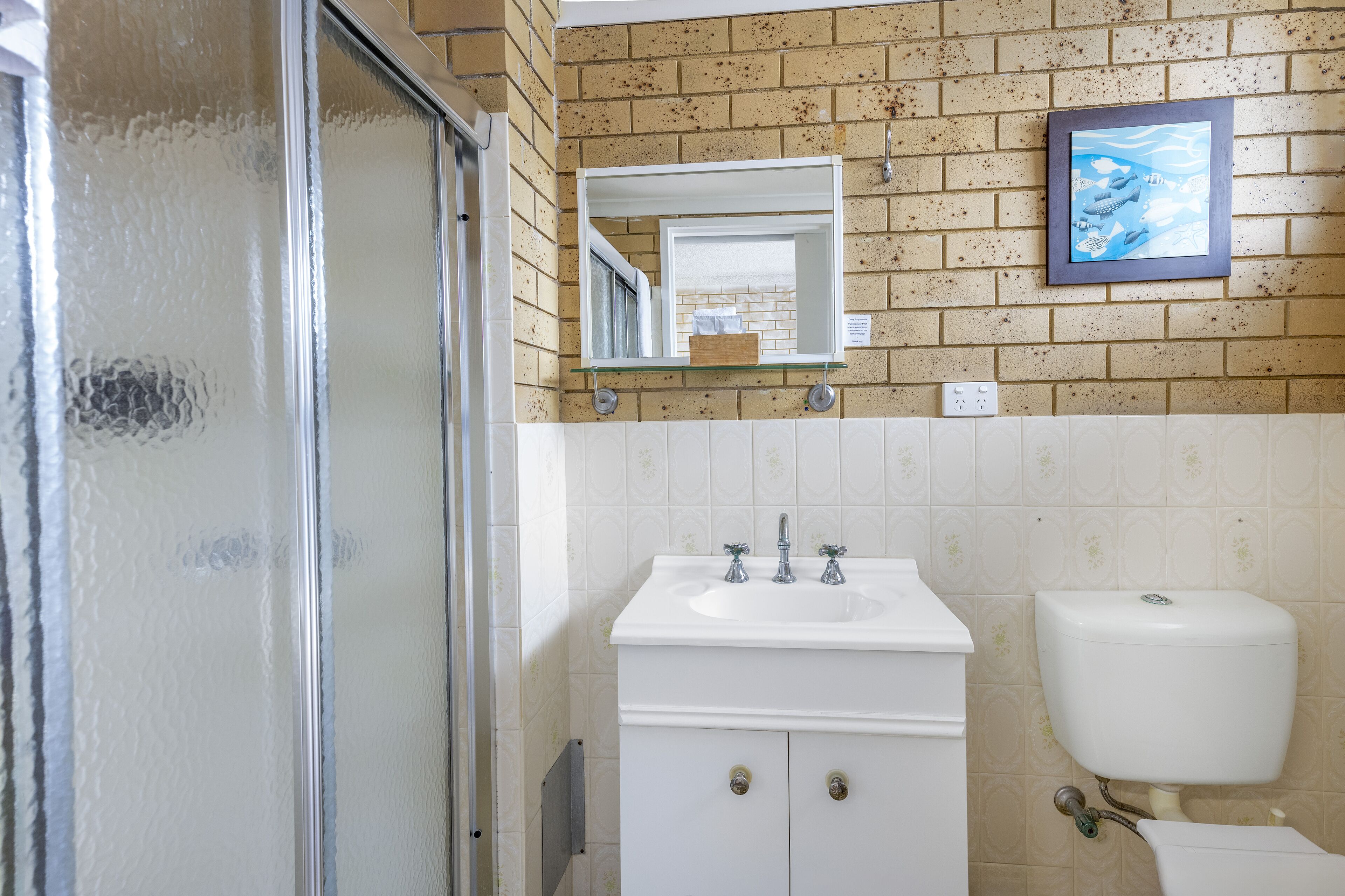 Ein Badezimmer mit Waschbecken, Spiegel und Toilette.