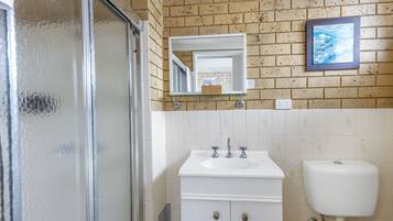 Ein Badezimmer mit Waschbecken, Spiegel und Toilette.