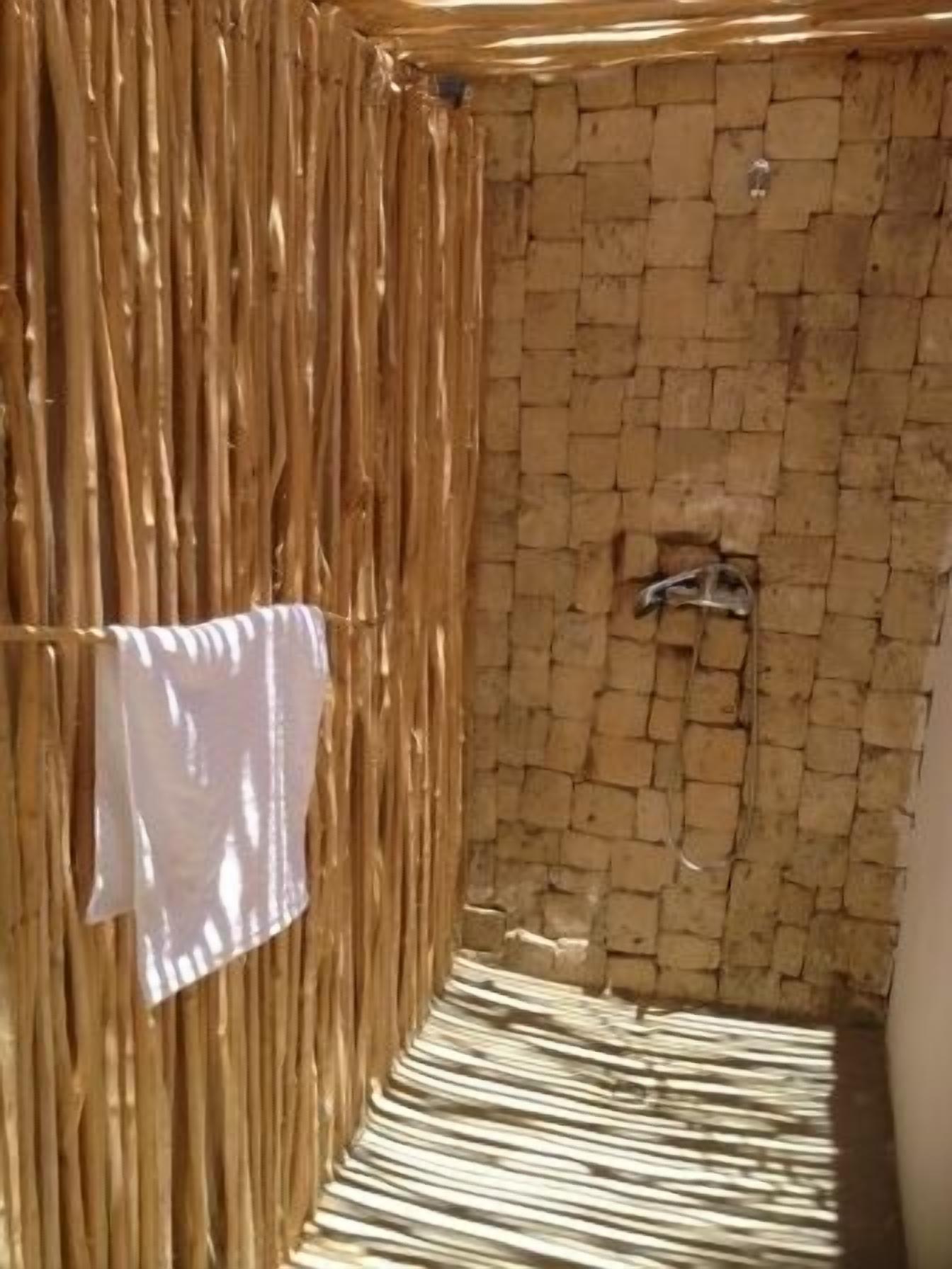 A room with a bamboo wall and a tiled floor.