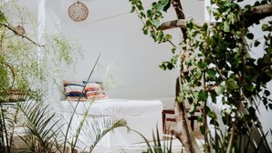 A white room with a bed, a hanging basket, and a plant. - Princesse du Lagon (Ifaty)