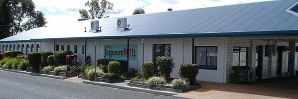 A motel with a flat roof, air conditioning units, and a sign that reads "Pepperroth Motel". - Peppercorn Motel (Clermont)