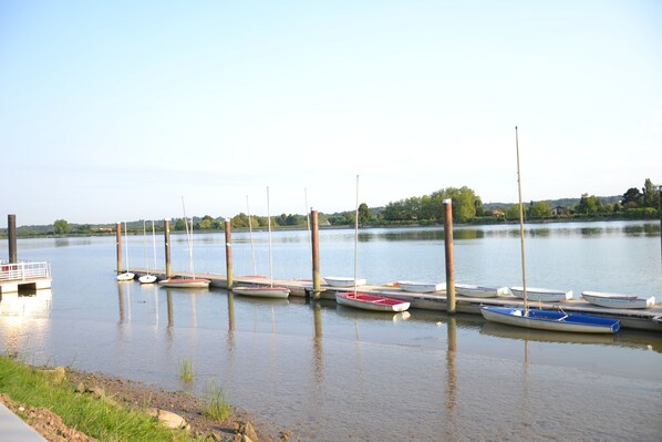 A calm lake with several small boats docked at wooden piers. - Adonis HĂ´tel Bayonne (Lahonce)