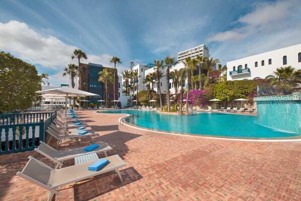 Alberca al aire libre, sombrillas en la alberca y camastros 