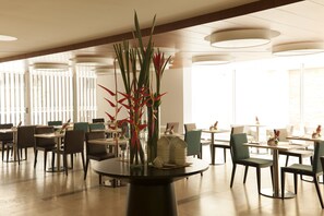 Enjoy meals in a stylish dining area with a round table, tall vase, and comfortable seating.