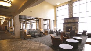 A spacious lobby with a stone fireplace, comfortable seating, and large windows. - Doubletree by Hilton Bemidji (Bemidji)