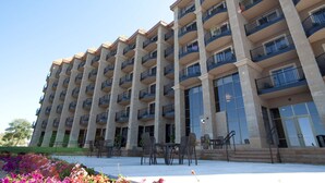 A multi-story hotel with balconies, outdoor seating, and a landscaped garden area. - Doubletree by Hilton Bemidji (Bemidji)
