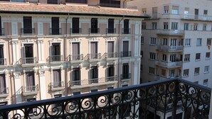 Un edificio de varios pisos con balcones y barandilla de hierro forjado.