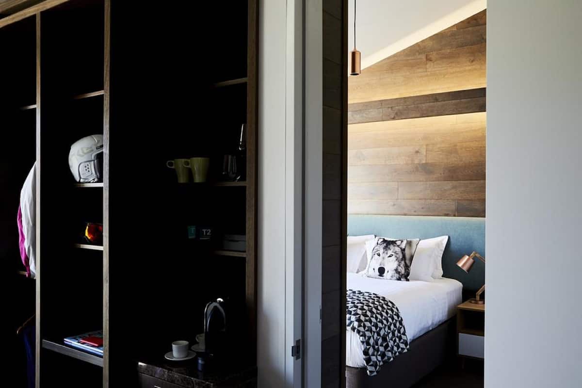 A bedroom with a bed, a nightstand, and a wooden headboard.