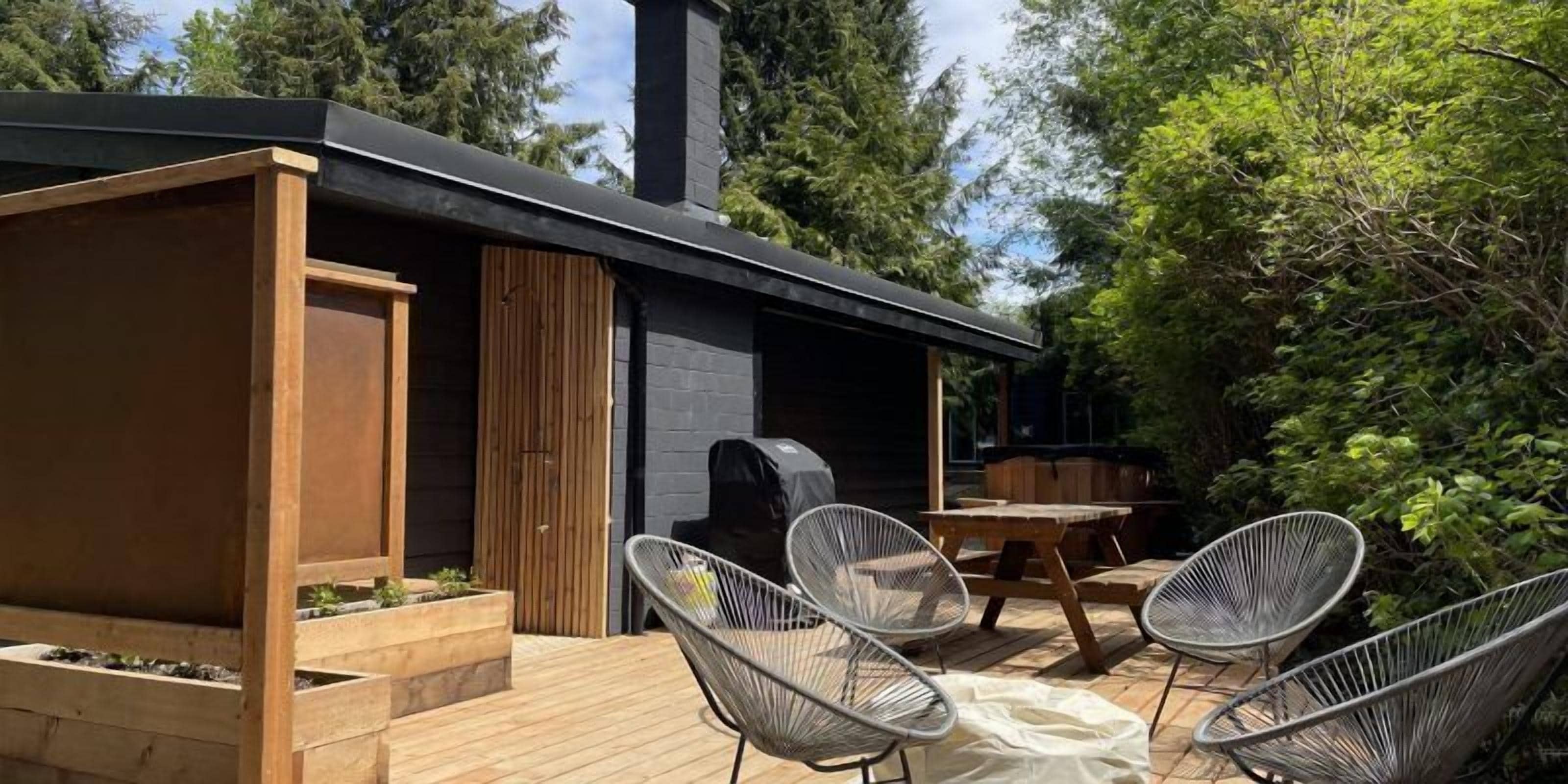 A wooden deck with outdoor seating and a barbecue area.