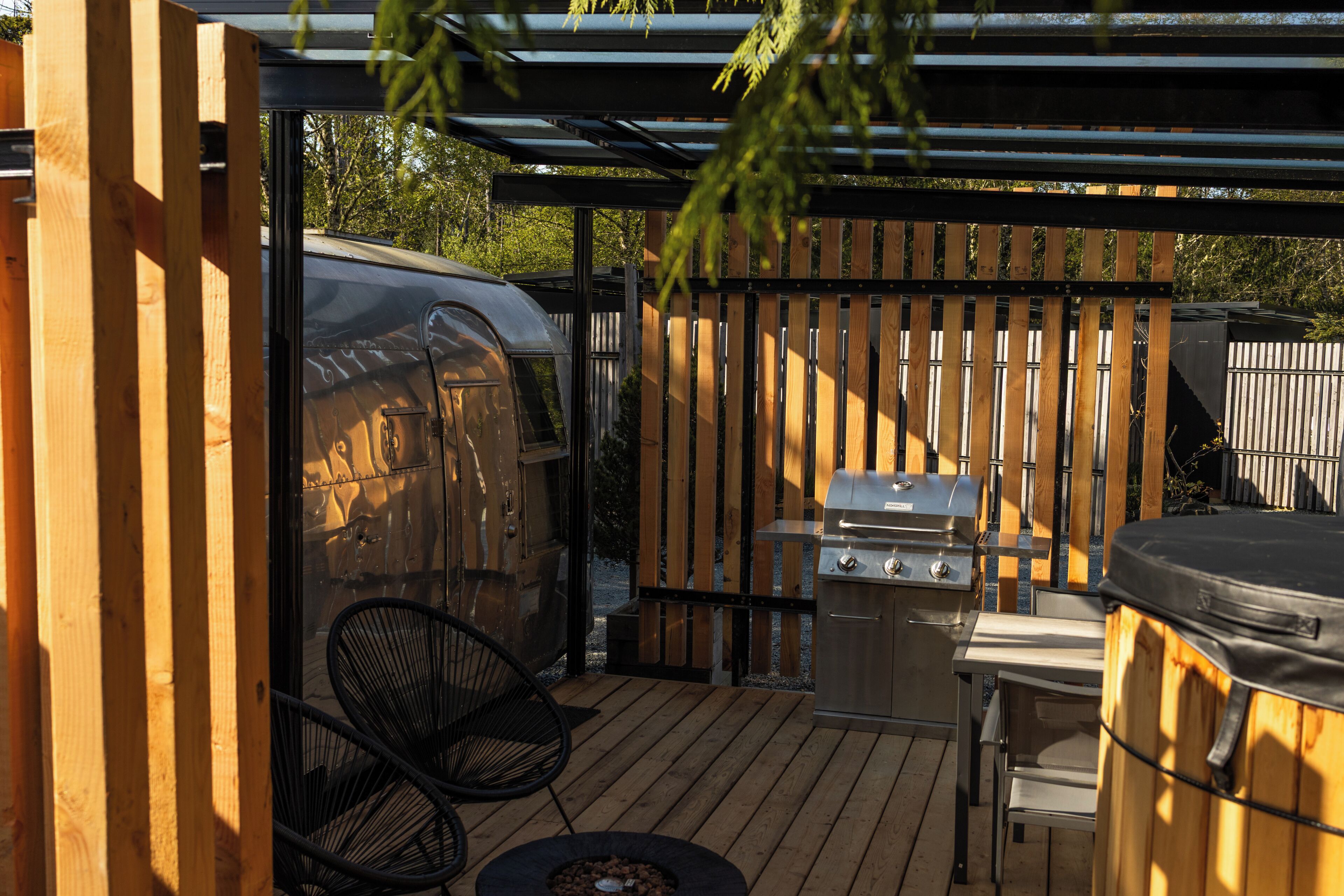 An outdoor patio with a grill, a barbecue, and a covered seating area.