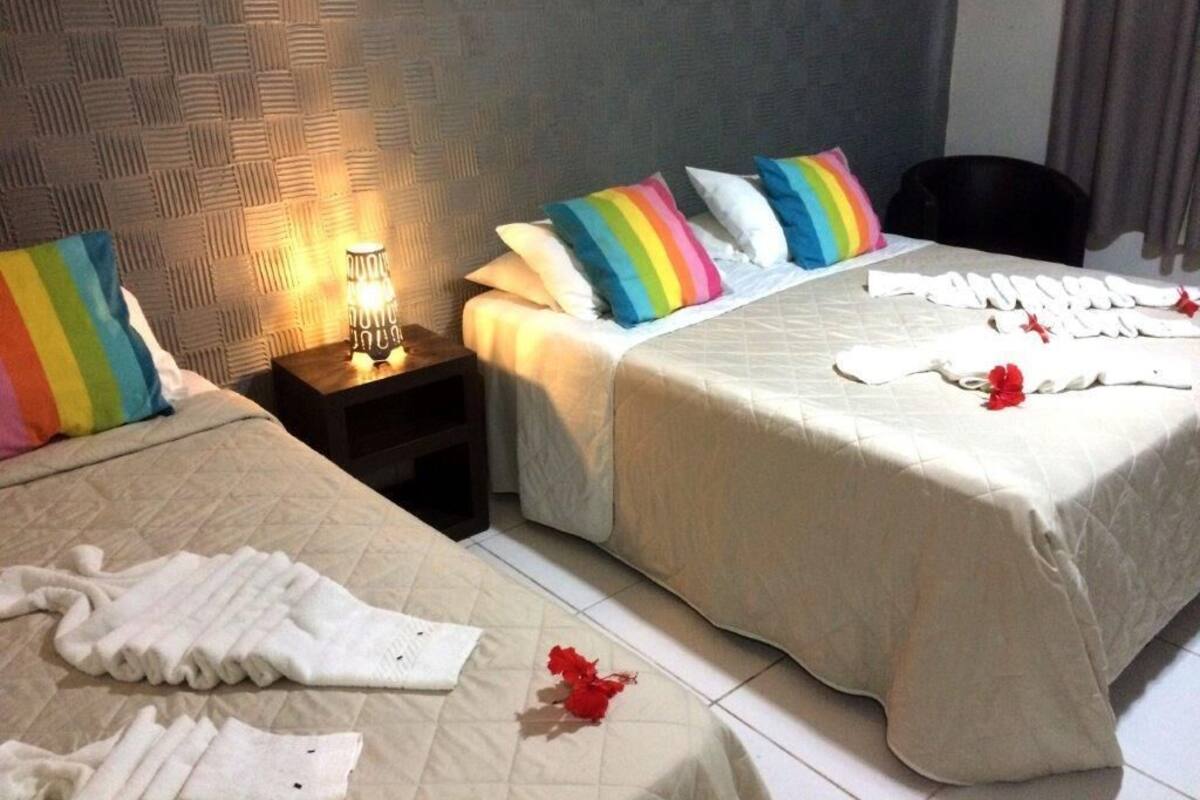 Habitació d'hotel amb dos llits, una taula de nit amb una làmpada i una cadira.