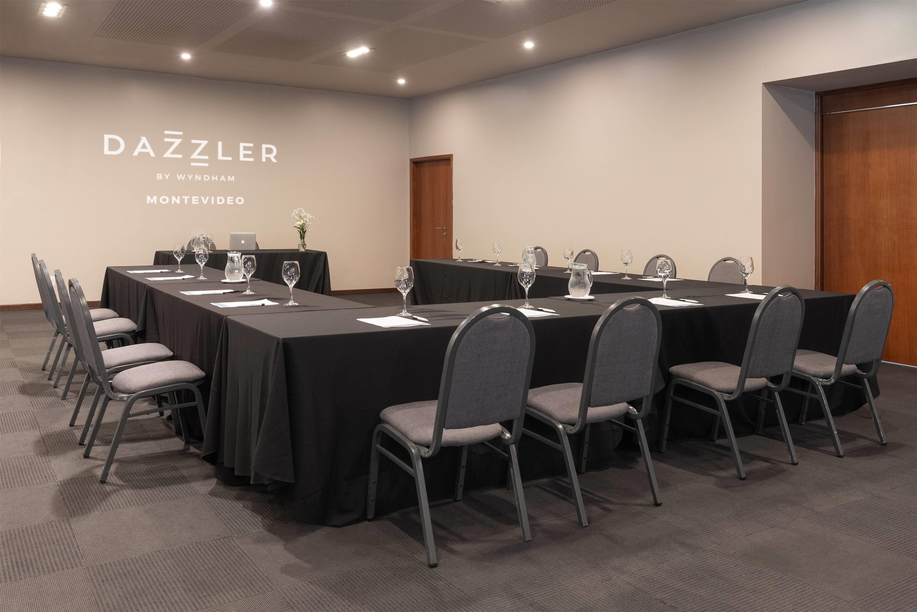 A conference room with a long table, chairs, and a laptop.
