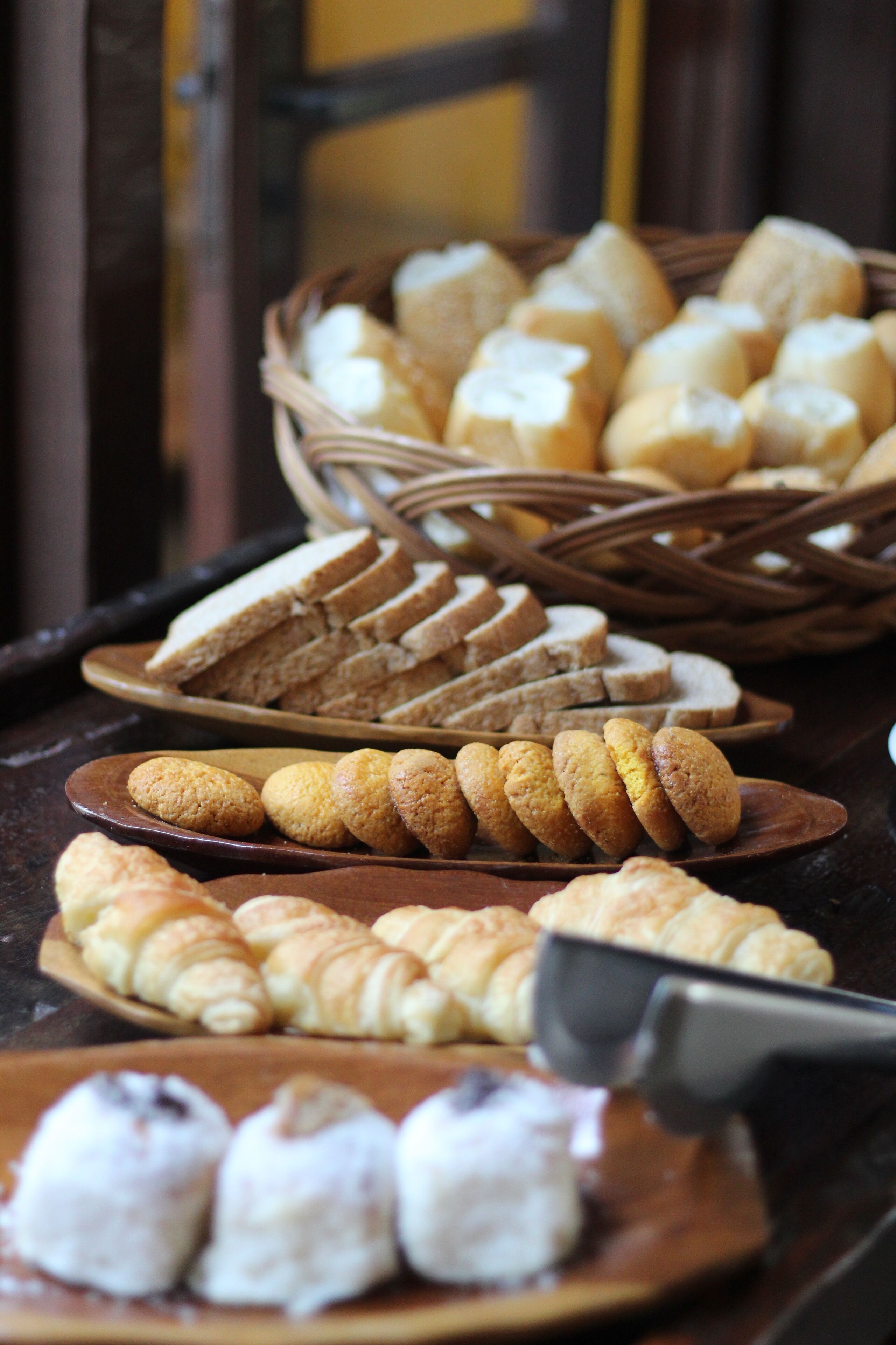 Diversitat de productes de forneria exposats en plats i cistades, com pa, croissants i galetes.