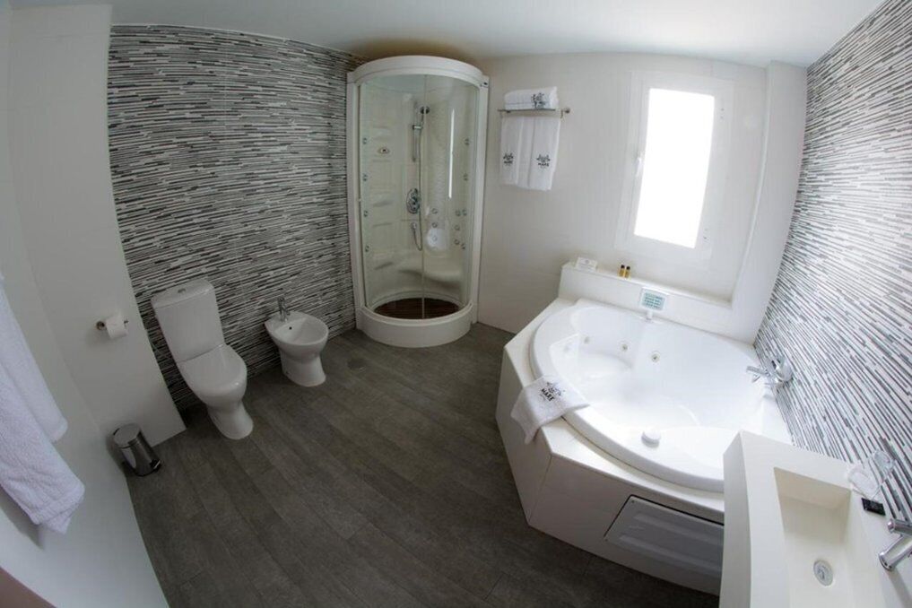 A modern bathroom with a glass-enclosed shower, a freestanding bathtub, and a standard toilet.