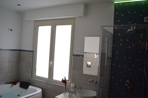 Un bagno con vasca, lavabo e zona doccia.