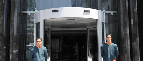La entrada del Hotel Rive, con una puerta de cristal y un giratorio.