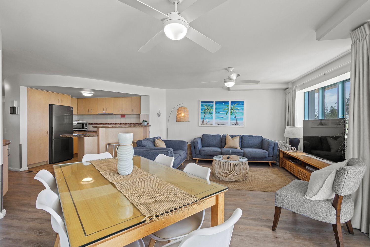 Un espacio de estar moderno con comedor, cocina y zona de asientos.