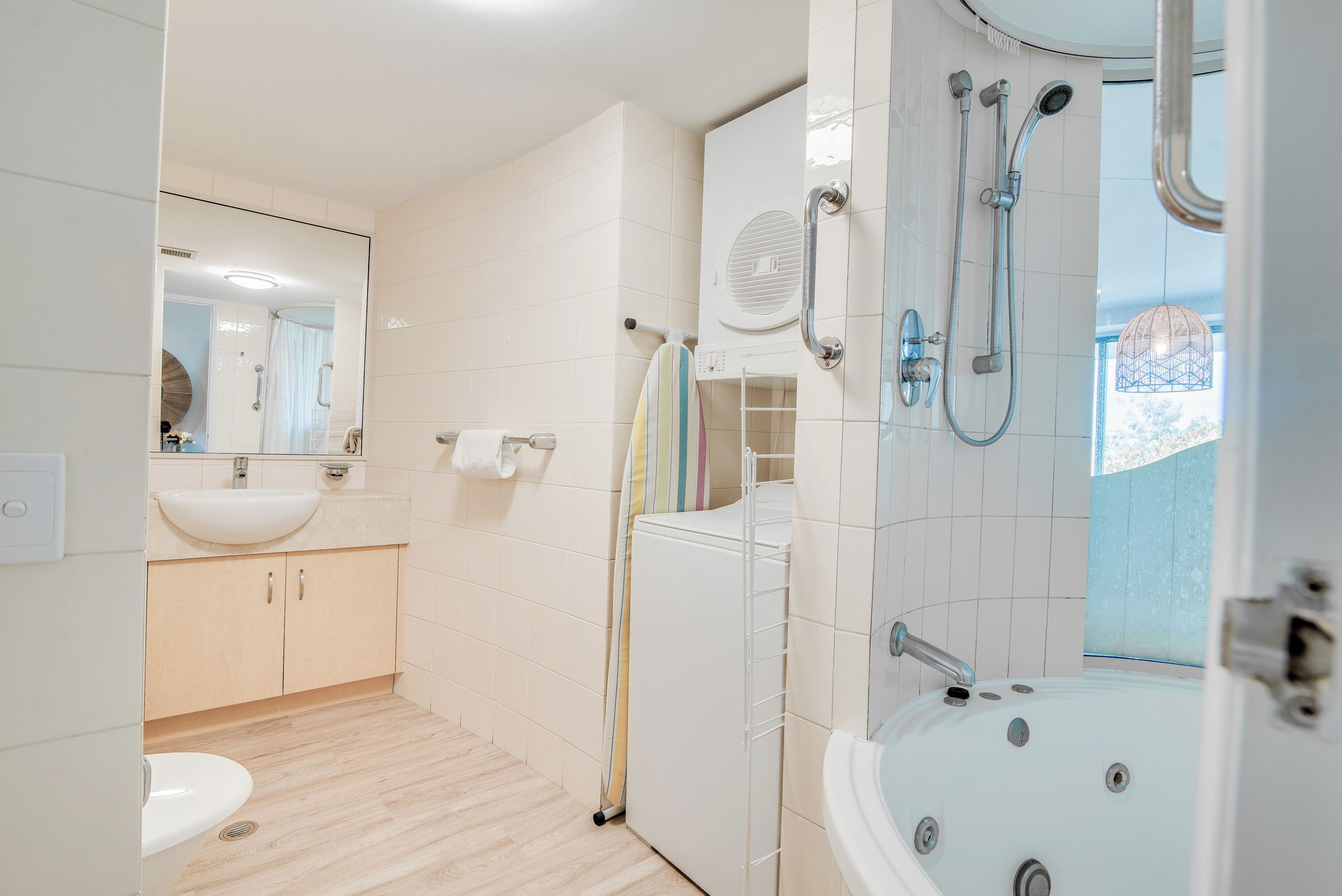 A modern bathroom with a sink, mirror, towel rack, shower, and bathtub.
