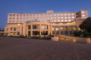 RAMADA hotel features a flat facade with balconies and a central entrance.
