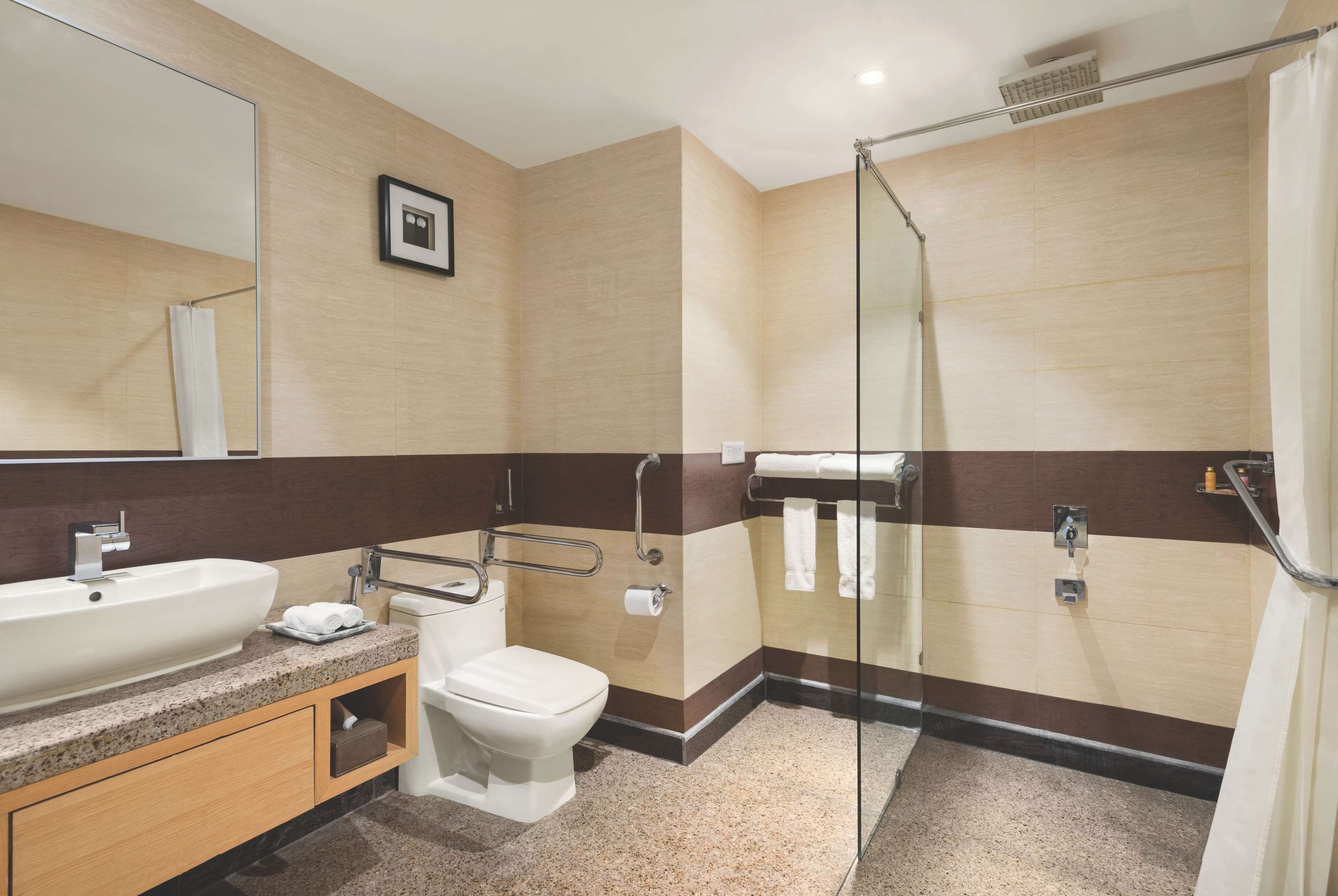 Une salle de bain moderne équipée d’un lavabo, de toilettes et d’une zone douche.
