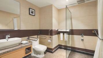 Une salle de bain moderne équipée d’un lavabo, de toilettes et d’une zone douche.