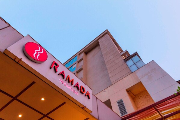 RAMADA hotel features a modern exterior with a flat roof and large windows.