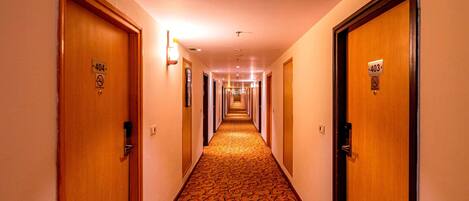 Pasillo de hotel con puertas numeradas 403 y 404, cubierto con un diseño de alfombra estampado.