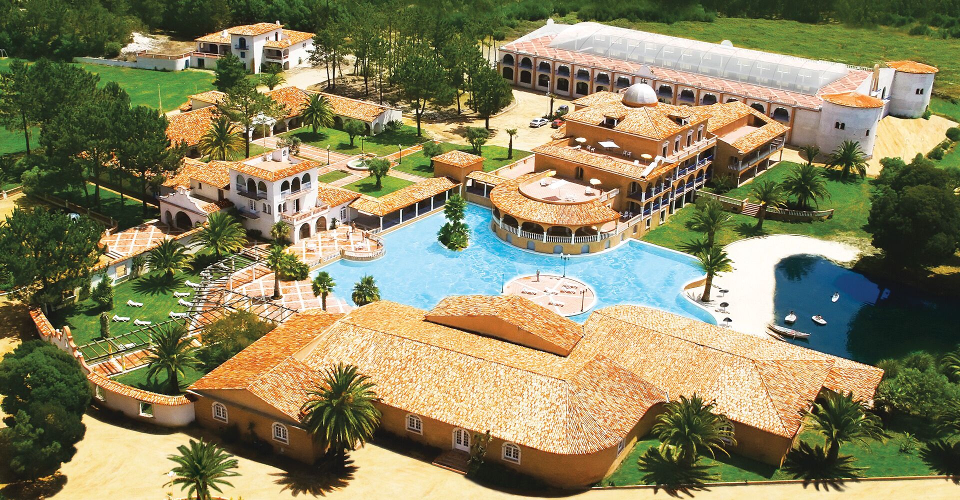 Ein Resort mit einem zentralen Pool, mehreren Villen und einem großen Gebäude mit einer Kuppel.