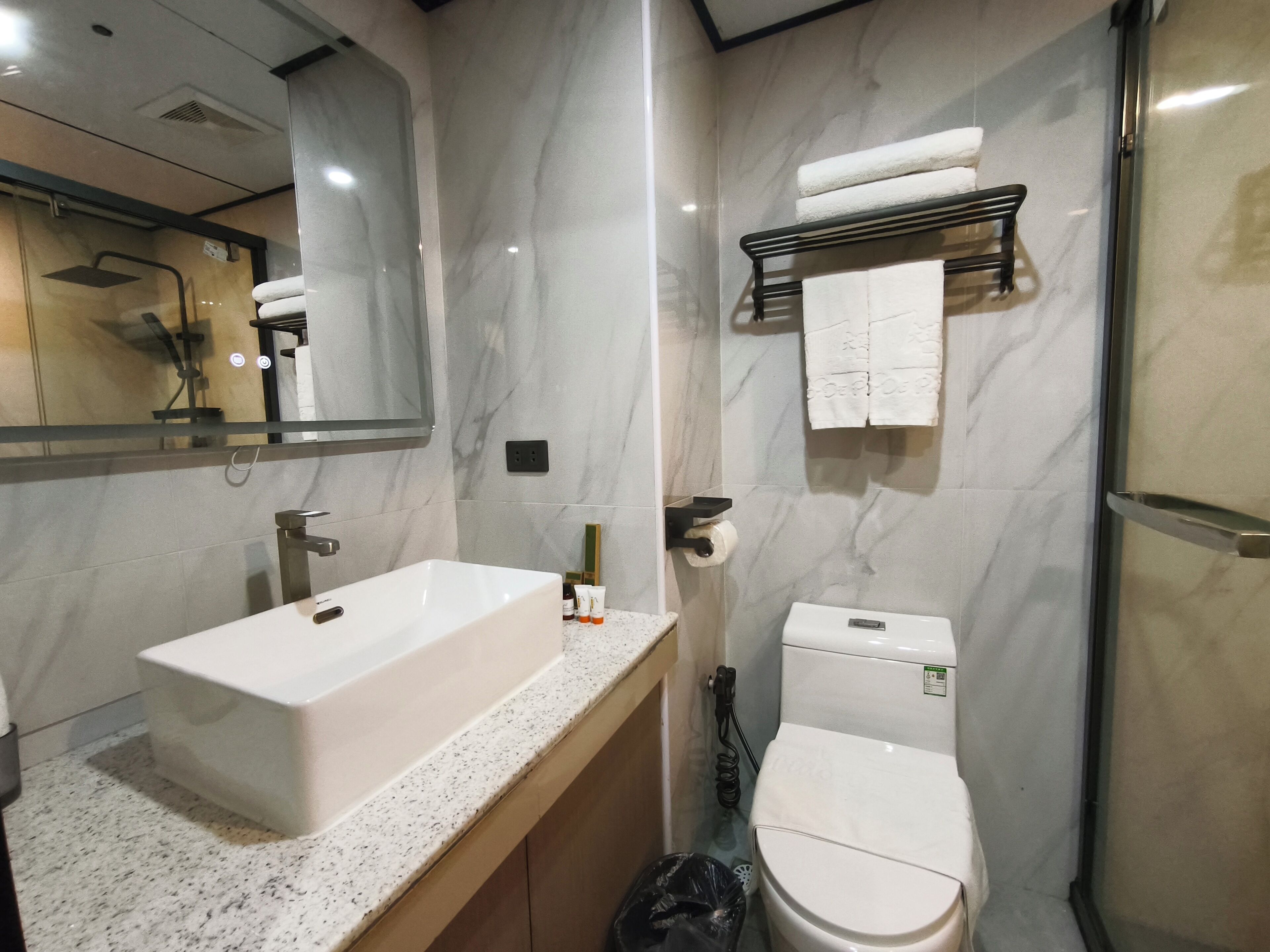 A modern bathroom with a large sink, toilet, and a mirror.