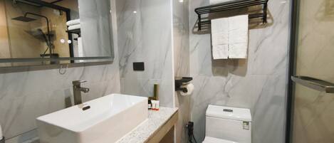 A modern bathroom with a large sink, toilet, and a mirror.