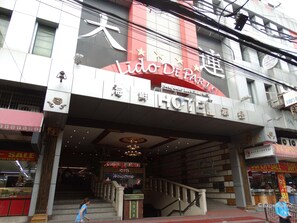 A hotel entrance with a staircase leading to the lobby.