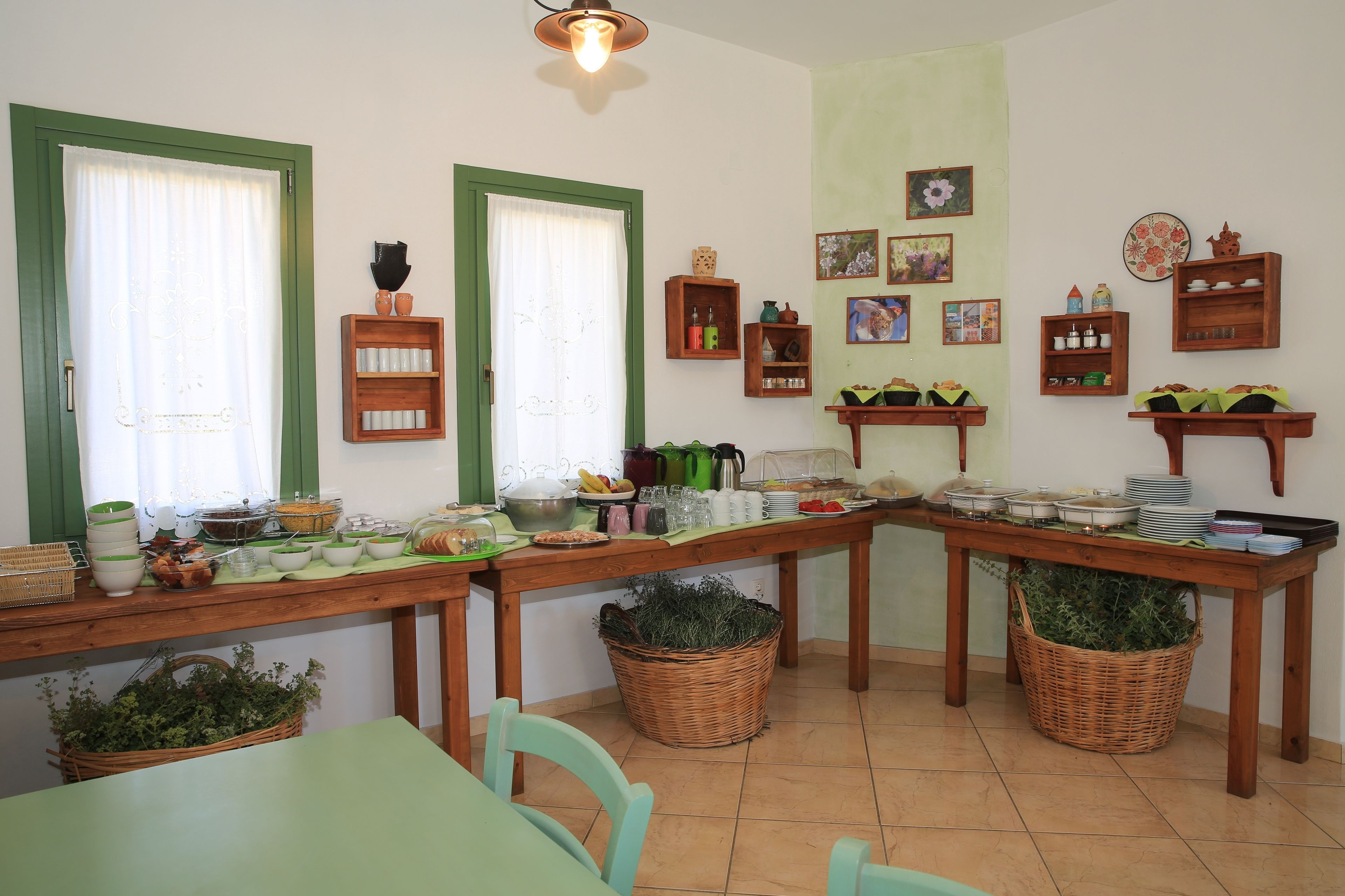 Zona de dinar amb menjar a la carta, finestres amb marc verd i diferents decoracions murals.
