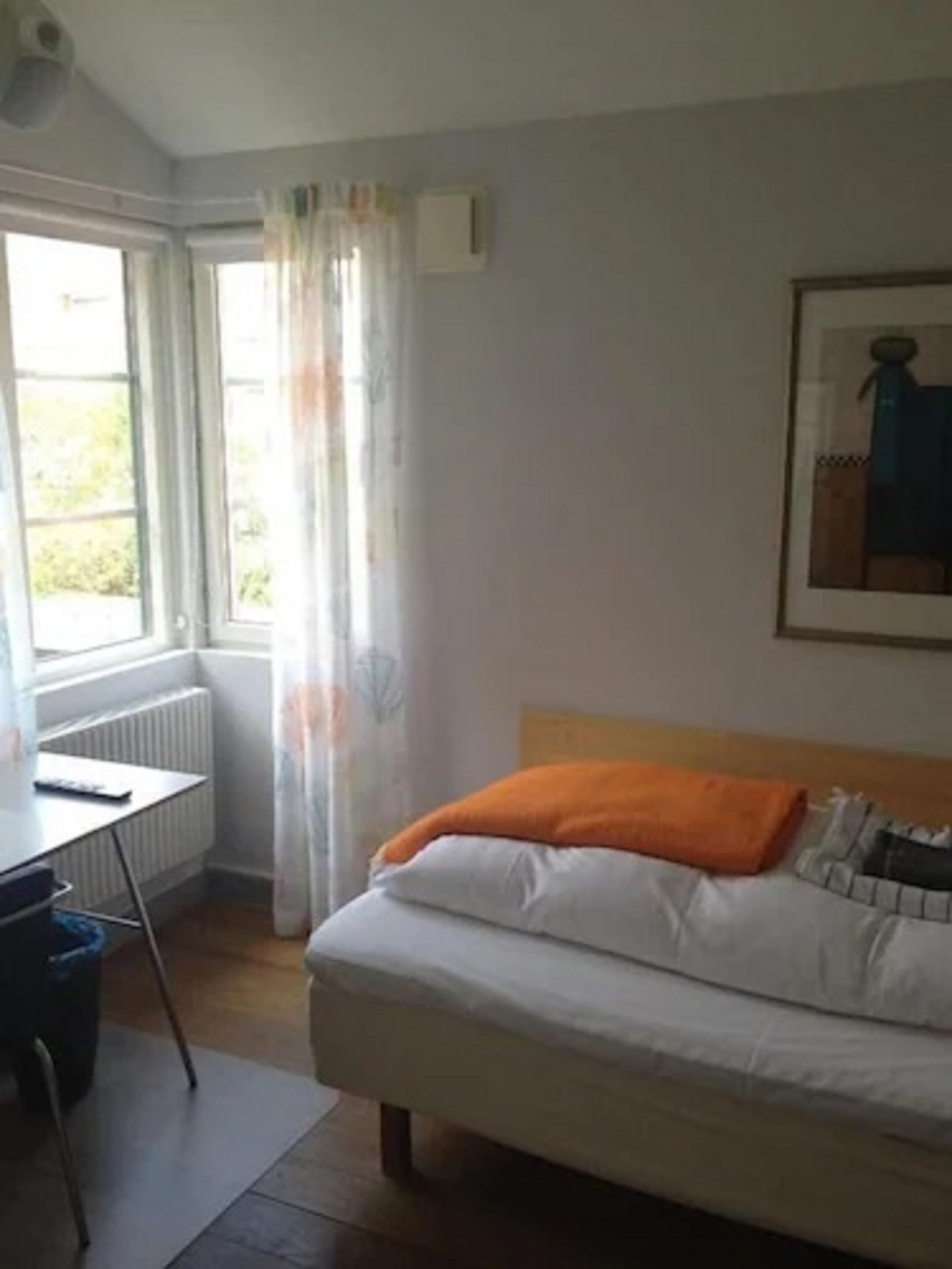 Une chambre à coucher avec un lit, un bureau et un radiateur.