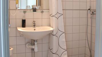 A bathroom with a shower, sink, and toilet.