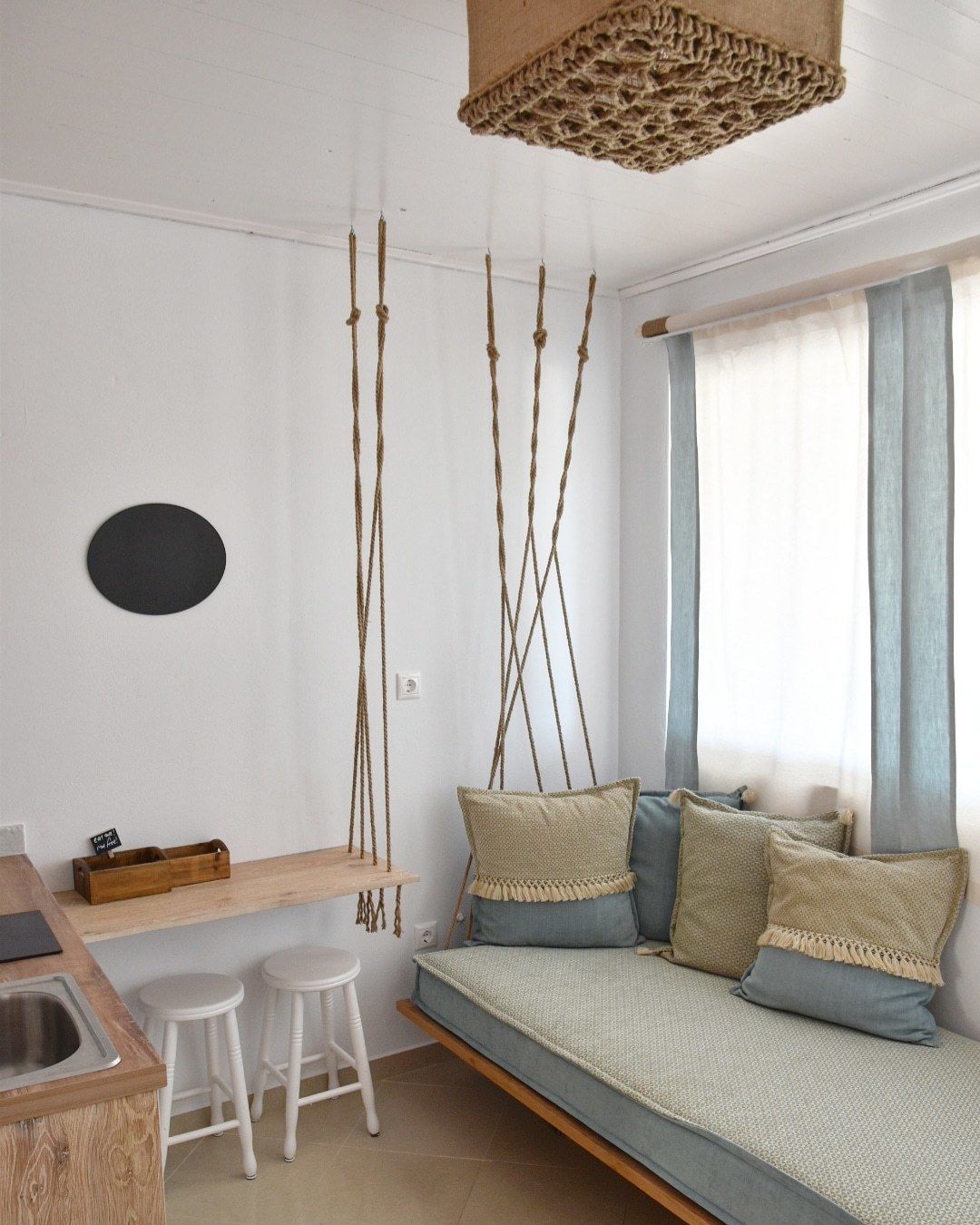A compact living space with a sofa, a small table, and two stools.