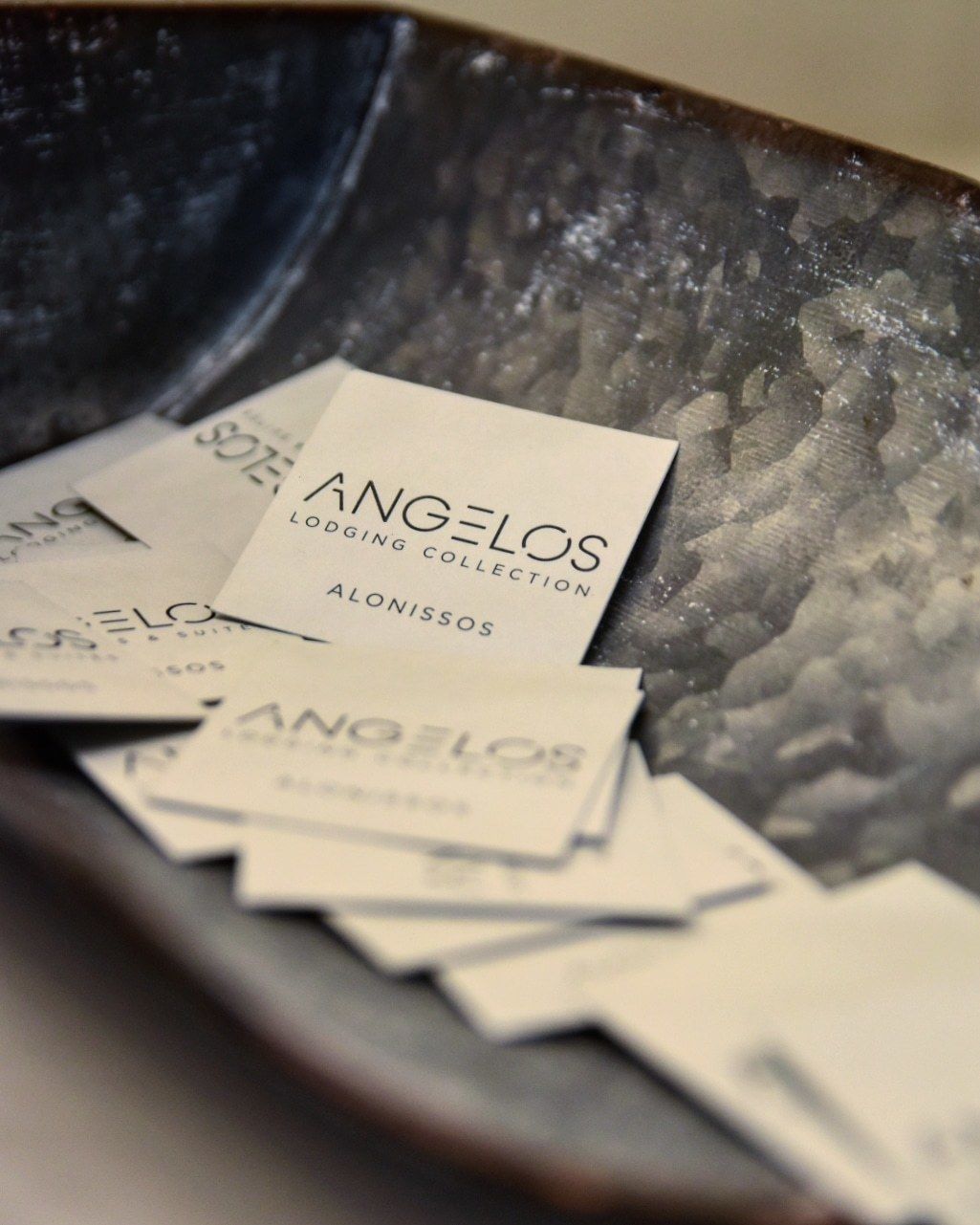 A collection of business cards with the text "ANGELOS LODGING COLLECTION" and "ALONISSOS" visible.