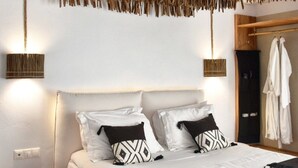 Quarto com cama grande, duas mesas de cabeceira, luminária pendente e guarda-roupa.
