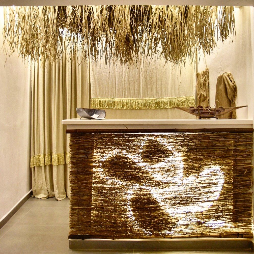 A reception desk with a woven design, a small bird figurine, and a decorative basket.