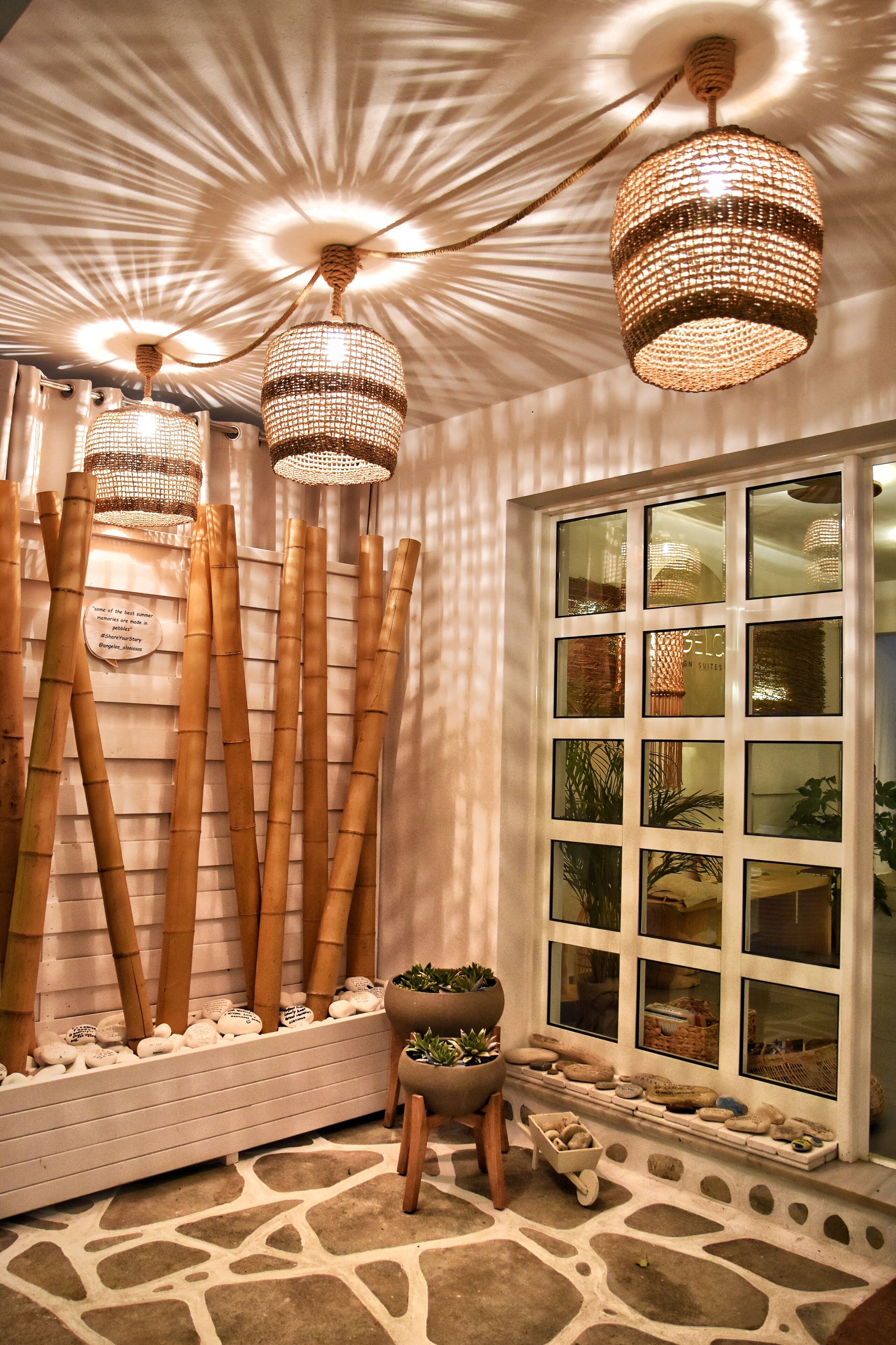 A room with bamboo decor, a window with multiple panes, and a small stool with a plant.