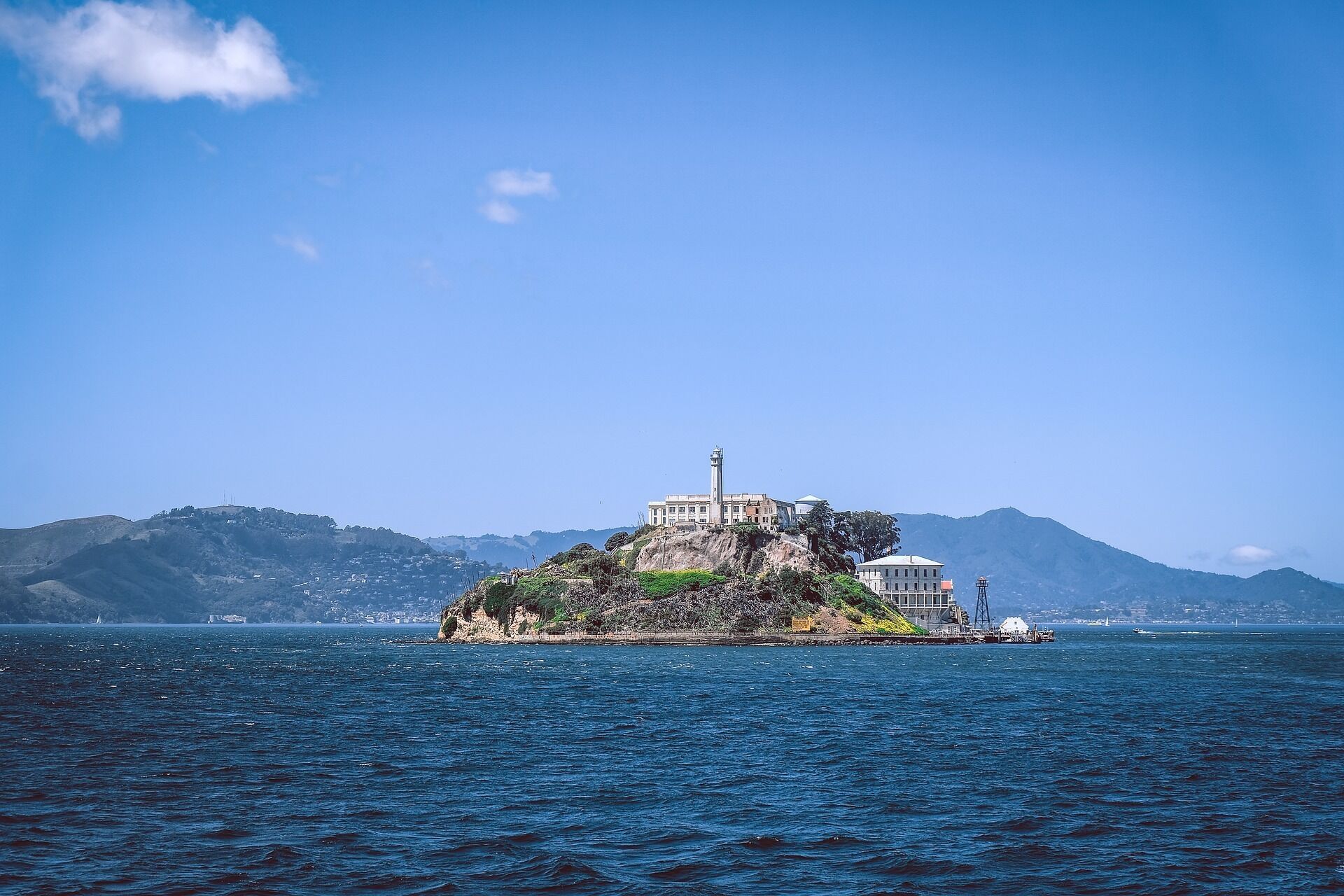 Un faro en una pequeña isla, con un edificio cercano.