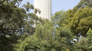 A stone staircase leading to a tower with arched windows, surrounded by trees.