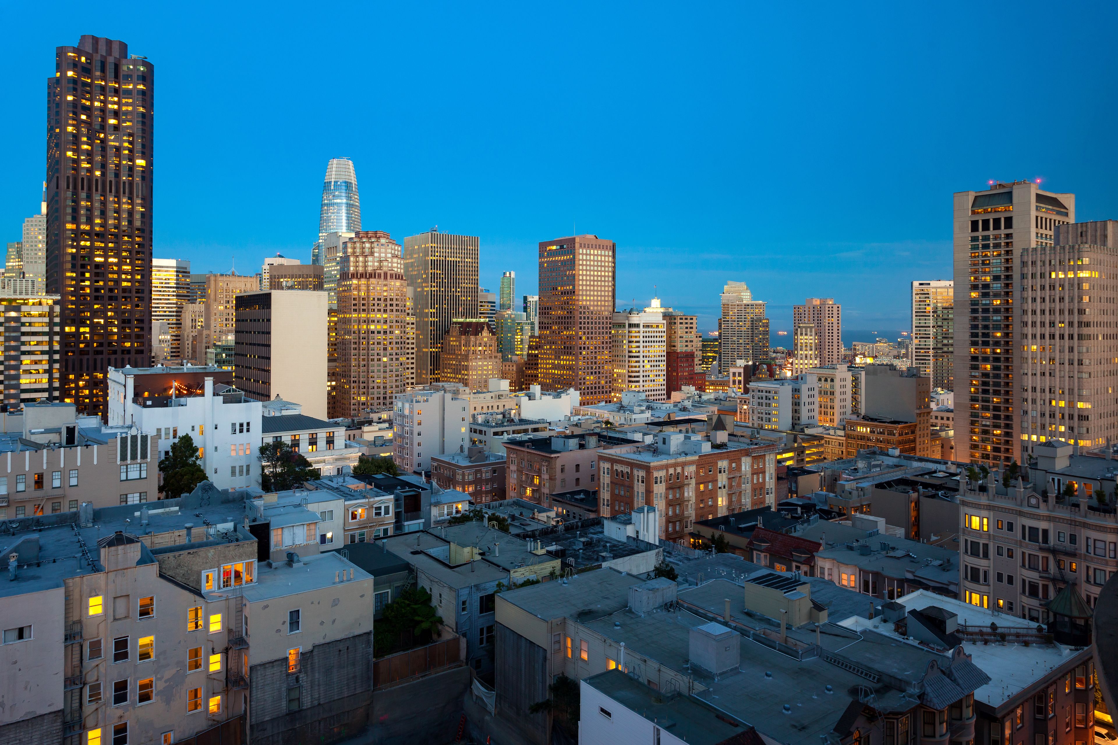 A cityscape with a variety of buildings, including high-rise and mid-rise structures, under a clear sky.