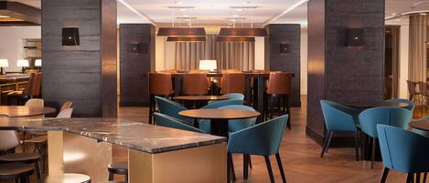 A modern hotel lobby with a bar area, seating arrangements, and a reception desk.