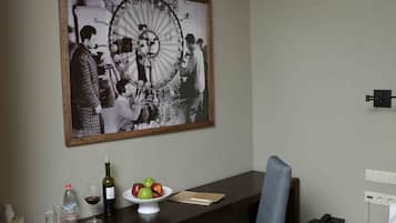 Habitación de hotel con escritorio, silla y una fotografía grande en blanco y negro en la pared.