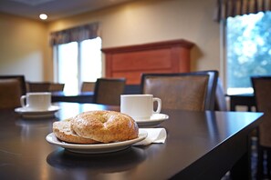 A dining table with a plate of pastries and a cup of coffee. - Quality Inn (Saugeen Shores)
